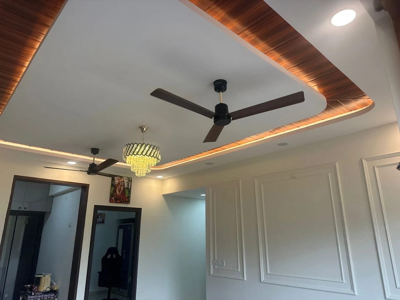 False ceiling with a timber-finish cove, concealed light and a crystal chandelier