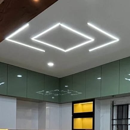 Linear ceiling lights reflected in gloss kitchen shutters