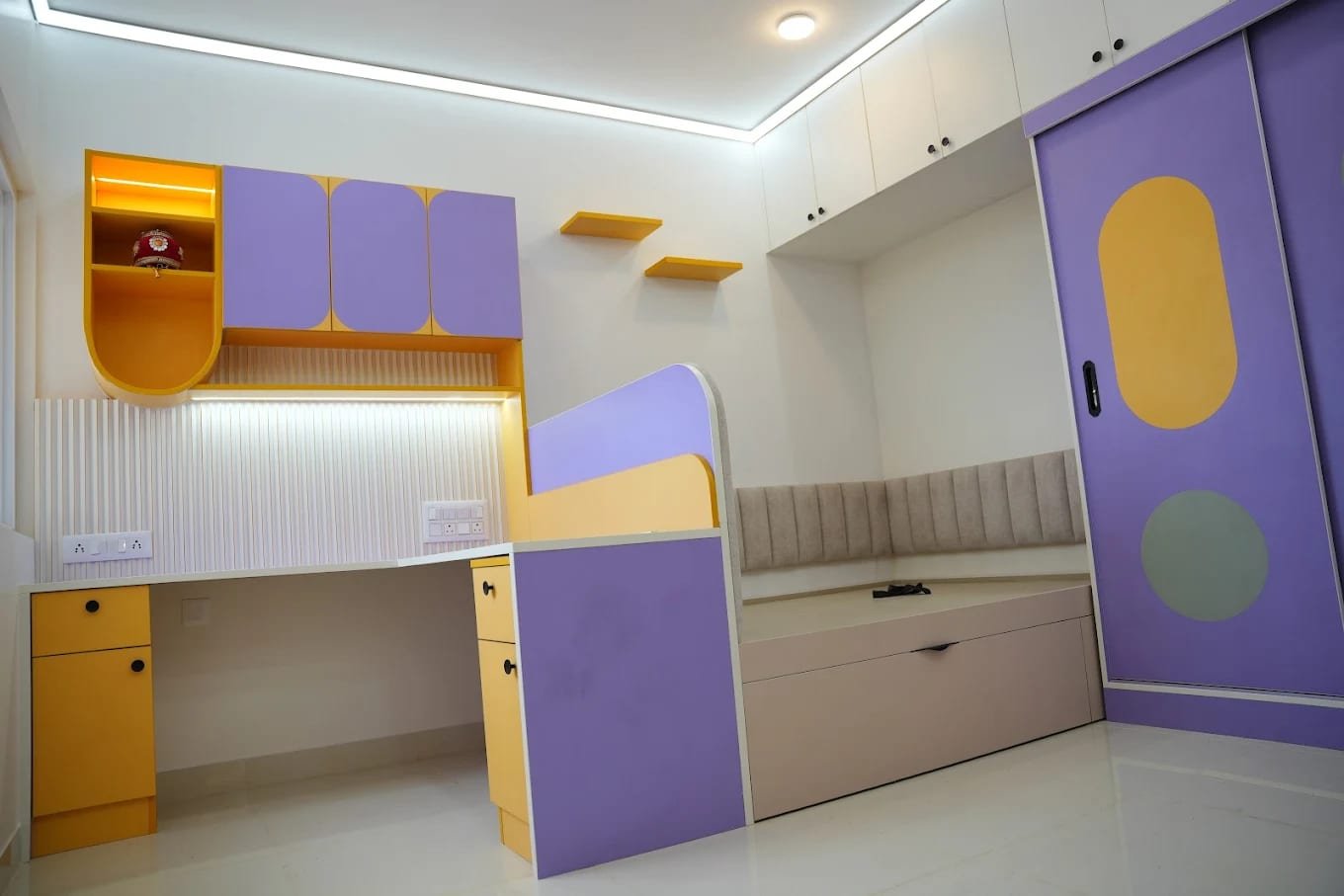 Kids' room with a study desk, rounded wall cabinets, cushioned daybed and sliding wardrobe in lavender and yellow