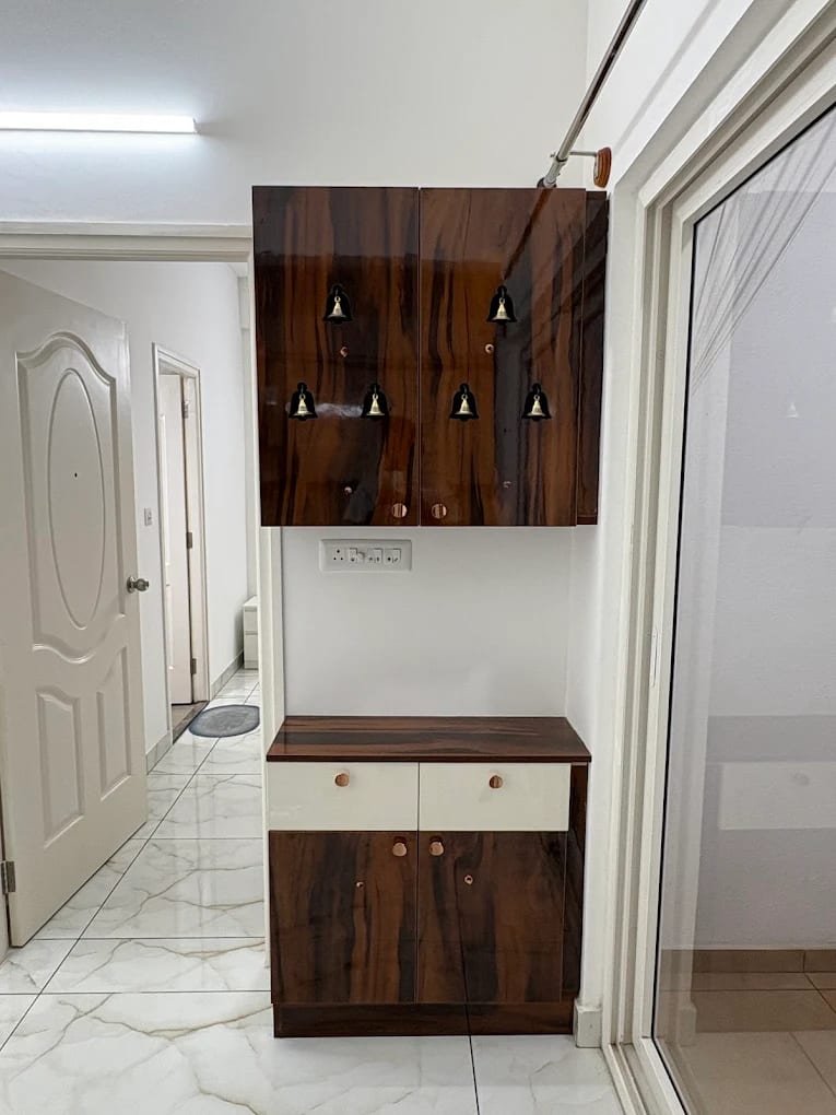 Wall-hung unit in high-gloss walnut finish with brass bell details above a base cabinet with drawers